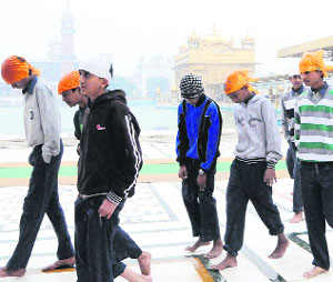 Devotees enjoy showers at the Golden Temple in Amritsar on Thursday.