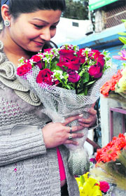 A girl buys flowers from a shop at Astley Hall in Dehradun on Thursday. 