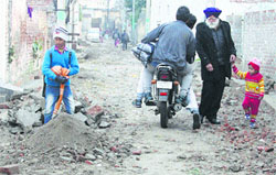 Commuters pass through an under-construction road 