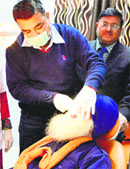 A dentist examines a patient on the inaugural day of Dental Fortnight at the Ludhiana Civil Hospital on Thursday. Photo: Inderjeet Verma 