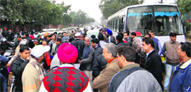 Applicants block the road in front of the SDM office in Industrial Area, Phase I, Chandigarh, on Friday.