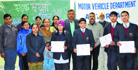 Assistant RTO, Reasi, along with students during an awareness programme on road safety at Jawahar Navodaya Vidyalaya in Reasi on Friday.