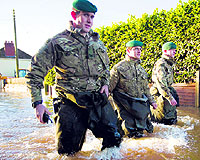 UK battles floods: British Royal Marines wade through flood waters on a street in Moorland, 19 km from Taunton, on Friday, as they take part in flood relief operations