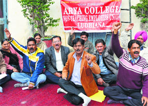 Non-teaching employees stage a dharna at Arya College in Ludhiana on Saturday. 