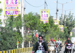 Illegal hoardings showing photos of politicians hung on streetlight poles in Jalandhar.