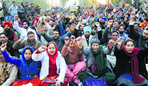 Members of the Punjab Computer Teachers Union protest on the road dividing Sectors 51 and 52 in Chandigarh on Monday.