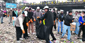 Cabinet minister Preetam Singh Panwar, along with district officials, removes garbage from a riverbed in Dehradun on Monday.