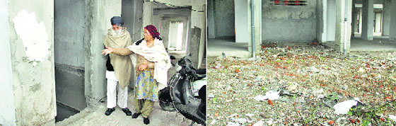 An elderly couple shows a point where the lift was supposed to be installed (Left) and An open manhole at the entrance of Nitishree Apartment in Jalandhar. Tribune Photos: Sarabjit Singh 