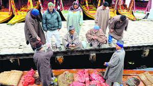 People buy vegetables from a boatman on the banks of the Dal Lake in Srinagar on Monday.
