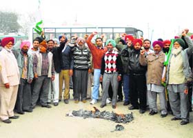 Protesters burn an effigy of the state government during a protest in Jagraon on Monday