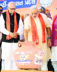 Gujarat CM Narendra Modi with LK Advani donate for the Modi for PM Fund for Election in Gandhinagar on Monday