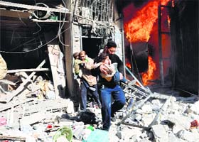 Men carrying children run out of a burning building following a barrel bomb attack in Aleppo city