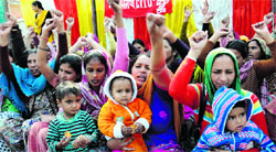 ASHA workers shout slogans against the state government with their children in Bathinda on Tuesday. Tribune photo