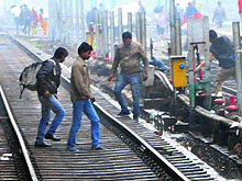 Passengers cross the railway track to reach other platforms at the Amritsar railway station despite the risks involved
