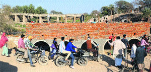 Commuters pass through a temporary bridge at Jagatpura village, in Mohali, on Wednesday