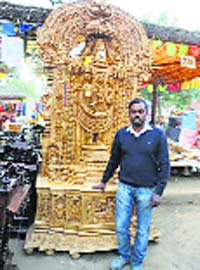 Chander of Mysore with the idol of Lord Balaji at his stall in the Surajkund International Crafts Mela on Wednesday