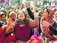 Krishna, mother of deceased Akhil Chauhan, and other residents protest in Karnal on Wednesday