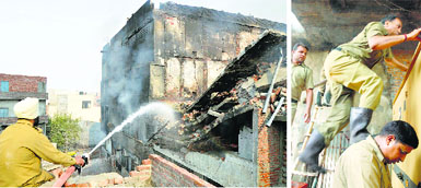 Firemen try to douse flames in the absence of hydraulic ladder and fire safety equipment. File photos