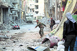 A Free Syrian Army fighter throws a rope as they prepare to put up curtains to provide cover from snipers loyal to Syria's President Bashar al-Assad in Deir al-Zor