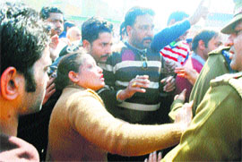 Police officials try to pacify traders blocking the Ambala-Jagadhri road in Ambala on Thursday.