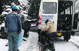 Vehicles caught in a fresh spell of snow in Mussoorie on Friday.