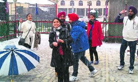 Tourists enjoy snowfall in Mussorrie on Friday.