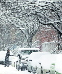 A motorist clears snow from a vehicle in Albany