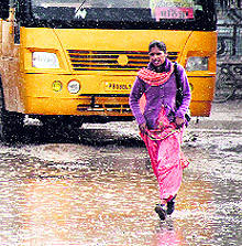 A woman runs for cover after alighting from a bus as it poured