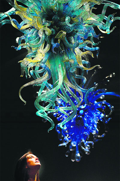 A woman poses for pictures with an artwork entitled ‘Aqua Marine’ during a photo call for an exhibition by US artist Dale Chihuly entitled ‘Dale Chihuly: Beyond the Object’ at London’s Halcyon Gallery. PHOTOs: AFP