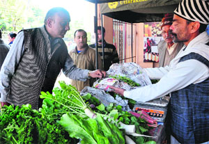 A person buys organic vegetables from a farmer at Doon Haat at Survey Chowk in Dehradun on Sunday. The Uttarakhand Organic Commodity Board has arranged the stall for the farmers in order to assist them to sell their produce.