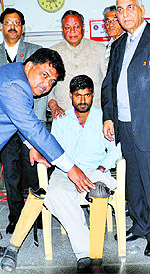 Volunteers give an artificial limb to a physically challenged man in Ludhiana