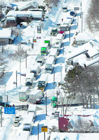 Trucks and cars are stranded by heavy snow on a national road in Karuizawa on Sunday