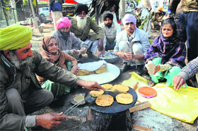 Agitating farmers prepare their breakfast in Bathinda on Monday.