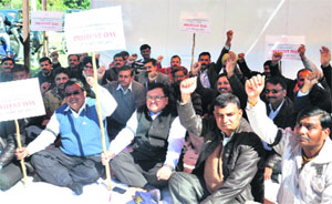 Members of the MES Builders Association of India stage a protest in Dehradun on Monday