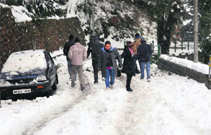 Tourists enjoy snowfall in Musoorie on Monday