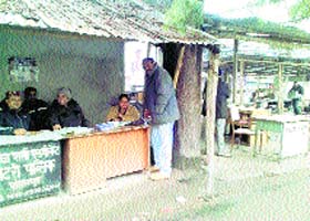 Stamp vendors and document writers work in open sheds in the biting cold at Palampur on Monday