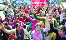 Members of the Jammu and Kashmir ICDS Supervisors Union and J&K Anganwari Workers and Helpers Union protest in Jammu on Monday. Tribune photo: Inderjeet Singh
