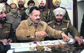 Policemen display gold ornaments recovered in Jalandhar on Monday.