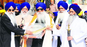 Akal Takht Jathedar Giani Gurbachan Singh and SGPC chief Avtar Singh Makkar felicitate Bhai Gurmej Singh in Amritsar on Monday.