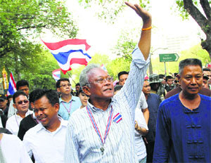 Leader of anti-government protesters Suthep Thaugsuban (C), waves to supporters during a rally on a street outside the Prime Ministers office in Bangkok on Monday
