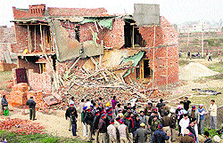 People gather near the collapsed under-construction house at Ladhewali in Jalandhar on Tuesday