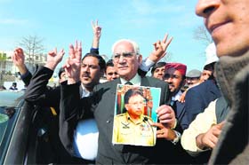 Pakistani lawyer Ahmed Raza Kasuri, representing former military ruler Pervez Musharraf, makes a victory sign alongside supporters after a case hearing in Islamabad on Tuesday