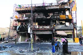 People gather at the site of a bomb attack in Baghdad's Karrada district on Tuesday
