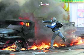 An anti-government protester throws a Molotov's cocktail during clashes with the riot police outside Ukraine's Parliament in Kiev