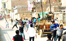 Rioters hurl stones at one another during caste violence in Sirsa on Thursday