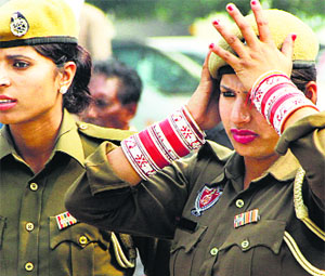 A newly wed woman in police uniform adjusts her cap in Jalandhar on Thursday.