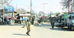 A paramilitary soldier patrols a street in Pulwama town during curfew on Thursday. A Tribune Photo