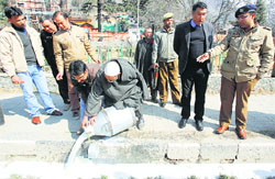 Health officer of the Municipal Corporation Dr Shafqat Khan and other MC officials destroy adulterated milk in Srinagar on Thursday. Tribune photo: Amin War 