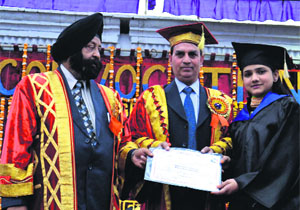 Guru Nanak Dev University Registrar Dr Inderjit Singh confers degree on a student at Hindu College in Amritsar on Friday.