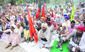 Farmers shout slogans outside the District Administrative Complex in Bathinda on Friday.